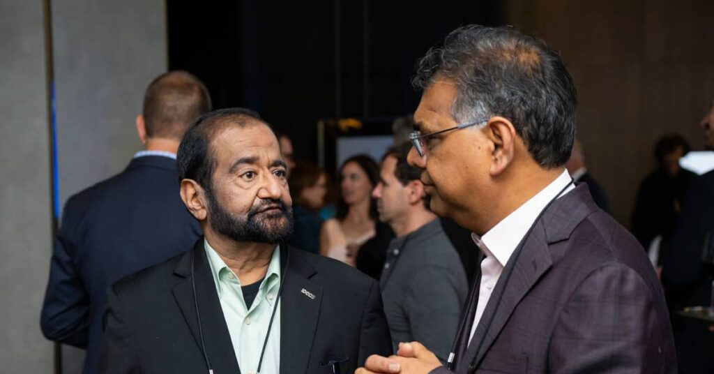 Candid photo of Dr. Ravi Mehrotra and Sanjay Nagalia chatting at an IDeaS event.